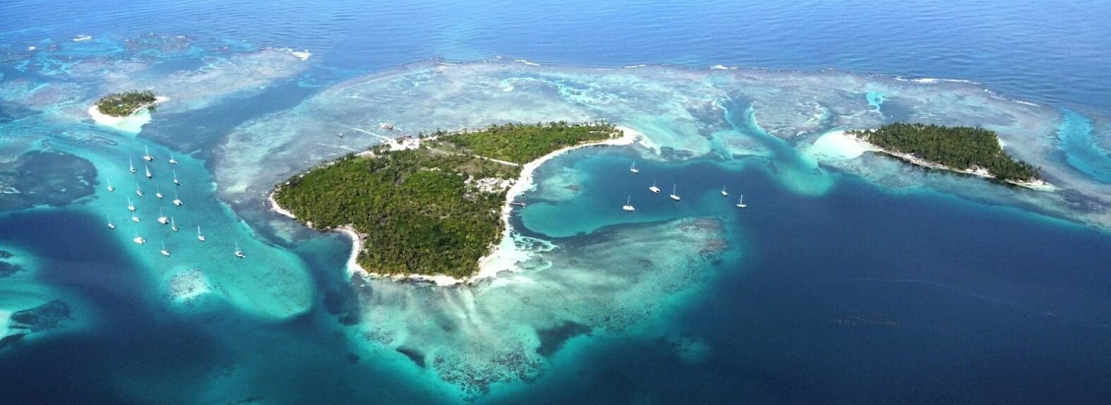 San Blas Island Hopping by Sailboat Aerial view of tropical islands, coral reefs and sailboats anchored in the turquoise waters of San Blas, Panama